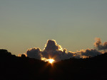 Die Sonne blinzelt vor dem Untergang  durch ein Wolkenloch