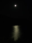 Das Licht des Vollmondes glitzert silbern im Meer vor Seccheto.